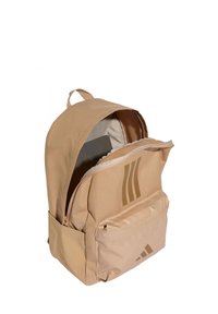 Zaino beige in tessuto resistente, con scomparto con cerniera, tasca frontale e logo con tre strisce diagonali. Manici nella parte superiore.