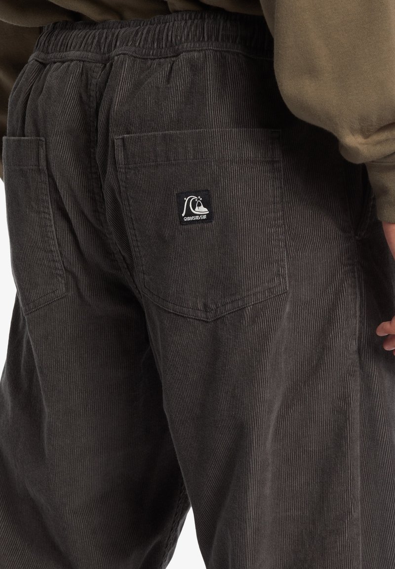 Grijze corduroy broek met een gestructureerd ribbelpatroon, een elastieken tailleband en twee achterzakken met een klein logolabel.