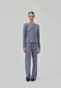 Set de lounge albastru strălucitor, format dintr-o bluză cu mâneci lungi și pantaloni evazați, confecționat dintr-un material moale, texturat, cu un model subtil de puncte.