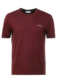 Bordeauxkleurig katoenen t-shirt met korte mouwen, ronde hals en een klein wit logo "Calvin Klein" op de linkerkant van de borst. Soepele textuur.