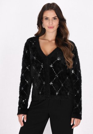 Černý chlupatý cardigan s výstřihem do V, výrazným diamantovým vzorem, zdobený stříbrnými flitry a zapínáním na knoflík. Dlouhé rukávy s ribbovanými manžetami.