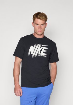 Schwarzes Baumwoll-T-Shirt mit einem großen weißen Nike-Logo im Pinselstrichdesign. Rundhalsausschnitt und kurze Ärmel. Schlichte und lässige Passform.