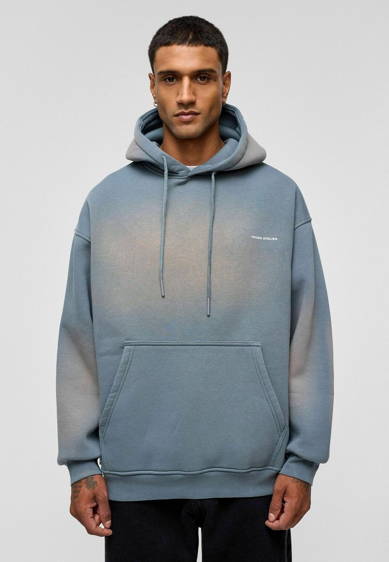 Lichtblauwe gradient hoodie van zachte stof. Voorzien van een buidelzak, aantrekkoorden en een logo op de borst. Klassieke pasvorm met ribgebreide manchetten.