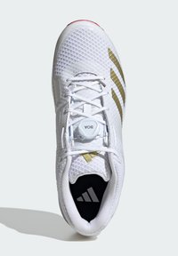 White athletic shoe with mesh upper, gold stripes, and BOA lacing system. Black insole features logo. Textured pattern on the surface.