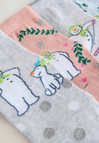 Three pairs of socks featuring winter-themed designs. Colors: gray, pink, and light blue. Patterns include snowmen, hearts, and polka dots.