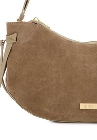 Brun suedetasker med en buet form, der har en guldfarvet lynlås, en beige rem og et guldlogo-tag på forsiden.