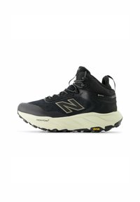 Scarpa da trekking nera a metà altezza con tomaia in mesh e sintetico, suola in gomma, logo in evidenza, lacci e marchio Vibram sulla suola.