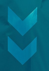 Teal stof med to store, glinsende, nedadgående chevron-mønstre i en lysere blå nuance, med en struktureret baggrund.
