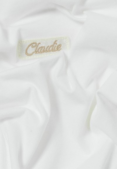 Tessuto bianco con una consistenza morbida, caratterizzato da un'etichetta con la scritta "Claudie" ricamata in beige chiaro su un'etichetta cucita.