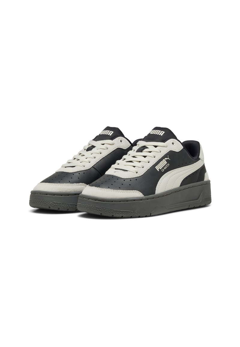Czarno-szare sneakersy z teksturowaną skórzaną cholewką, perforowanymi detalami i białymi akcentami. Posiadają grubą podeszwę i kontrastujące sznurówki.