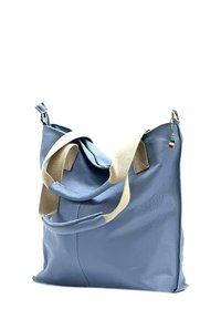 Blauwe leren tas met een gestructureerd oppervlak, voorzien van crèmekleurige canvas schouderbanden en een decoratieve driekleurige tag. Zacht, slonzig ontwerp.