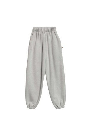 Jasnoszare dresy z elastycznym pasem i mankietami, o luźnym kroju, wyeksponowane na białym tle.