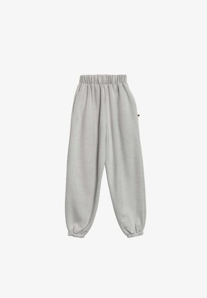 Jasnoszare dresy z elastycznym pasem i mankietami, o luźnym kroju, wyeksponowane na białym tle.