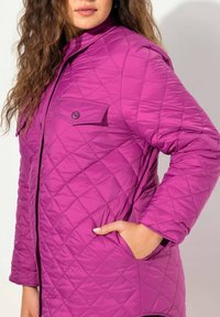 Kvadra jakke i lila med en knappad bröstficka, långa ärmar och sidfickor, med en strukturerad krage och en slät textur.