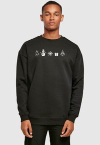 Svart sweatshirt med hvite festlige ikoner: en kopp, snømann, snøfnugg, gaveeske og juletre, med rund hals og ribbede mansjetter.
