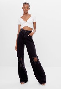 Bershka Mit Schlaghose Und Rissen Relaxed Fit Jeans Black Zalando De