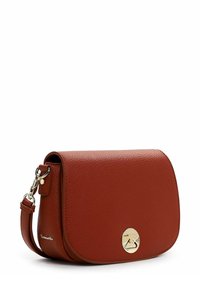 Bolso cruzado de cuero rojo con tapa curva, hardware circular dorado y correa ajustable. Superficie texturizada y líneas limpias.