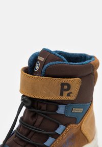 Brune og brune tursko med en teksturert overdel, blå detaljer, GORE-TEX-merke og snøring for sikker passform.