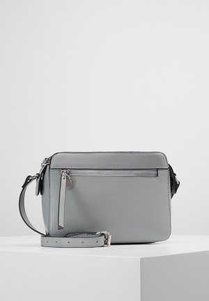 Szara prostokątna torba na ramię z przednią kieszenią na zamek i regulowanym paskiem na białym tle i powierzchni.