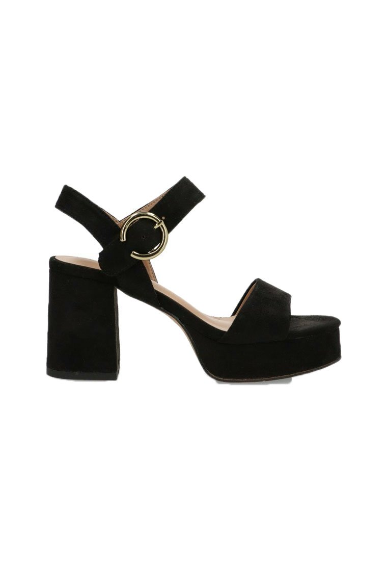 Sandalia de plataforma de ante negro con tacón grueso, tira ajustable al tobillo y detalle de hardware dorado circular. Textura suave y diseño sencillo.