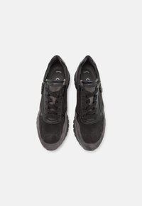 Schwarze Wildleder-Sneaker mit einer glatten Lederschicht, ausgestattet mit einem Reißverschluss, strukturierten Schnürsenkeln und einer stabilen Gummisohle für zusätzlichen Grip.