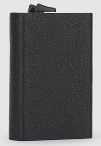 Quaderno rilegato in copertina nera con texture e una leggera lucentezza. Presenta una rilegatura superiore e un design semplice e fluido.