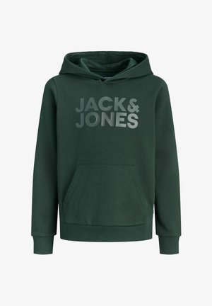 Dreng iført grøn Jack & Jones hættetrøje, rummelige lyseblå jeans, beige sneakers og grå kasket, som står og smiler mod en hvid baggrund.