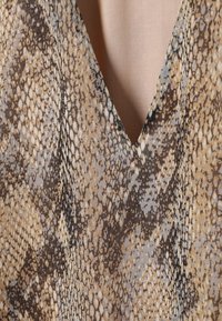 V-Ausschnitt-Oberteil mit Schlangenprint in Beige-, Braun- und Grautönen; glatte Textur mit leicht glänzendem Finish.