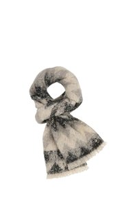 Écharpe en laine douce avec des motifs abstraits en zigzag noir et beige, bords à franges et une petite étiquette en métal ronde.