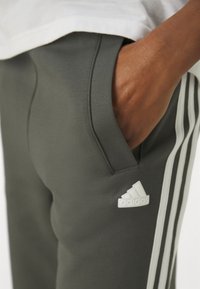 adidas Sportswear FUTURE ICONS - Jogginghose - legend ivy
