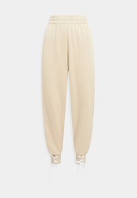 Beige sweatpants med smockad midja, avsmalnande ben och snörningar vid bensluten. Mjuk tygkvalitet, minimal logotyp på vänster lår.