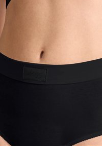 Svarta bomullsboxershorts med en slät midja som har en texturerad rektangulär tag. Tyget har en mjuk, matt finish och en vågig nederkant.