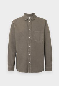 Camisa marrón de manga larga con botones, cuello y un bolsillo en el pecho, exhibida plana sobre fondo blanco.