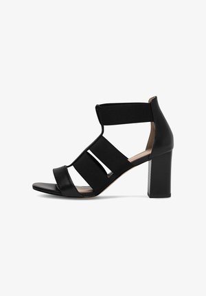 Sandalo con tacco alto nero con cinturini elastici, punta aperta e tacco spesso. Pelle liscia e tessuto elasticizzato garantiscono comfort.