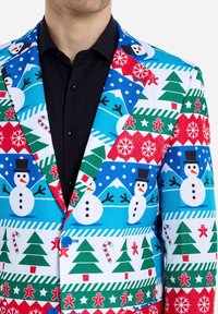 Jul-inspirerad blazer med en ljusblå bakgrund som har mönster av snögubbar, träd, pepparkaksgubbar och snöflingor i rött och grönt.