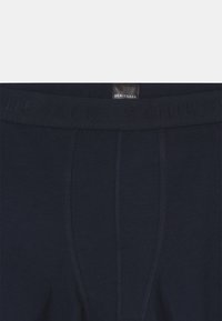 Boxer briefs blu navy con una vita texturizzata che presenta il nome del marchio "Schiesser" in rilievo. Tessuto in cotone liscio, dettaglio della cucitura centrale frontale.