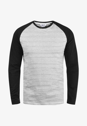 T-shirt a maniche lunghe con corpo bianco e sottili righe orizzontali nere, maniche raglan nere. Materiale in cotone.
