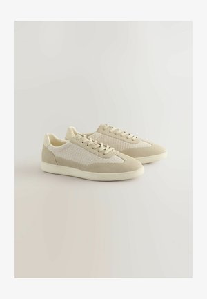 Baskets beiges avec un dessus en mesh et des accents en daim, présentant un bout rond, des lacets plats et une semelle en caoutchouc texturée.