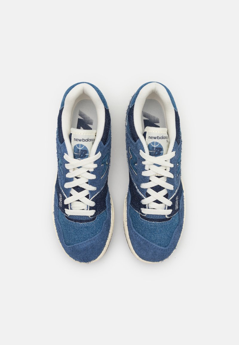 Sneakers bleus en daim et en denim avec des lacets blancs, featuring un design texturé et un logo sur la languette. Semelle ronde et rembourrée.