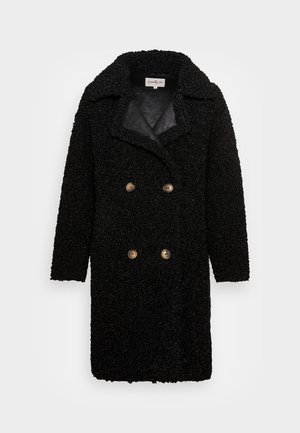 Manteau en laine noire texturée à double boutonnage avec larges revers et quatre boutons marron, longueur jusqu'aux genoux avec manches longues.