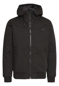 Veste noire à capuche avec fermeture éclair sur le devant, cordons, poignets côtelés, deux poches latérales zippées et une poche zippée sur la manche gauche.