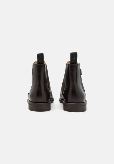 Brune skinn Chelsea-støvler med en glatt finish, rund tå og grønne pull-tabs. Lav hæl og sydd detaljer på sidene.