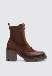 Botines marrones con un diseño de materiales mixtos, con puntera de cuero liso y laterales de ante texturizado, tacón grueso y cierre de cremallera.