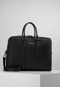 Mallette en cuir noir avec deux poignées structurées, une bandoulière amovible et des coutures verticales discrètes. Logo VALENTINO embossé.