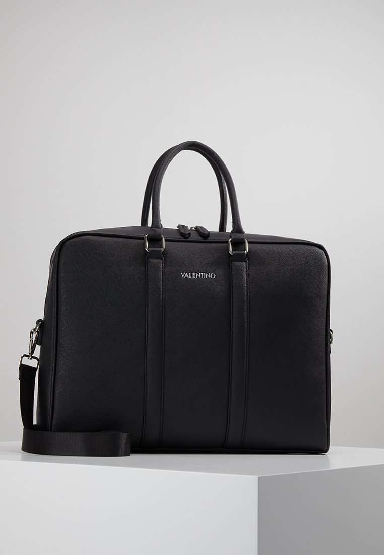 Mallette en cuir noir avec deux poignées structurées, une bandoulière amovible et des coutures verticales discrètes. Logo VALENTINO embossé.