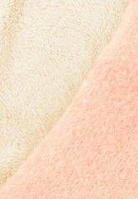 Lichtbeige en zachtroze pluche stof, met een pluizige textuur en een lichte glans, diagonaal gesplitst over de afbeelding.