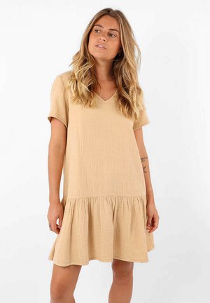Robe beige à manches courtes en tissu texturé, avec un décolleté en V et un ourlet évasé orné de volants en bas.