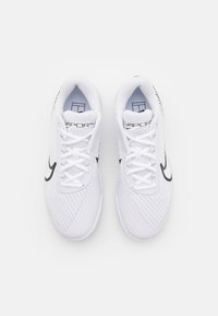 Baskets blanches de sport avec un dessus en maille, semelle texturée, swoosh Nike noir et logo "VAPOR PRO" sur la languette. Lacées avec des lacets plats blancs.