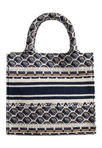 Kudottu kankainen olkalaukku, jossa on tummansinisiä ja kreeminvärisiä raitoja sekä aaltoileva kuvio, kaksinkertaiset kahvat ja rakenteellinen muoto.