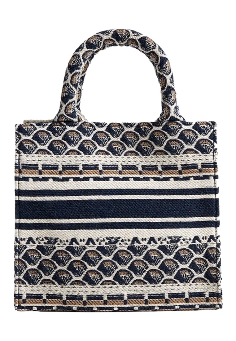 Kudottu kankainen olkalaukku, jossa on tummansinisiä ja kreeminvärisiä raitoja sekä aaltoileva kuvio, kaksinkertaiset kahvat ja rakenteellinen muoto.